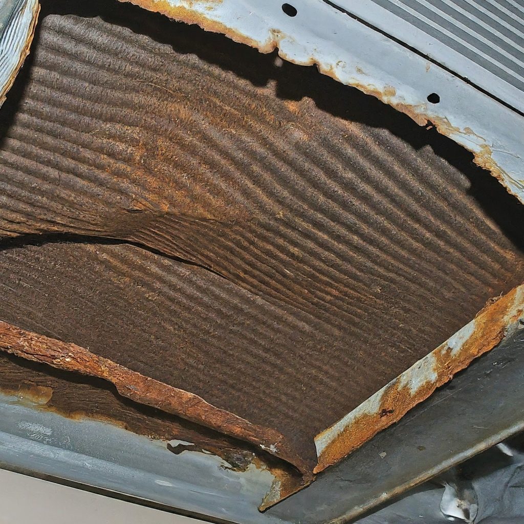 an image depicting a Damaged or Rusted Drain Pan of an air conditioner