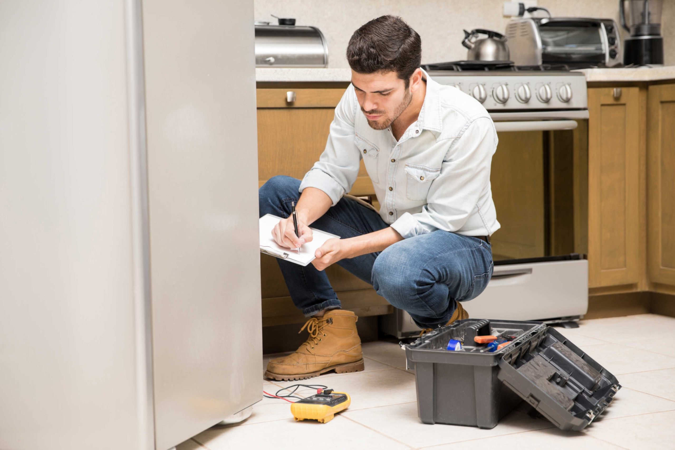 an image displaying a person trying to fix a freezer that is not working properly